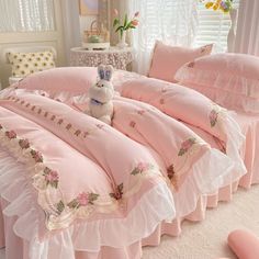 a stuffed animal sitting on top of a pink bed