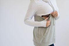 This is our #1 selling NURSING SWEATSHIRT and it comes in many color combos! The main reasons: the QUALITY fabric, LOOSE fit, and the TRENDY design! The material is super soft and washes great! **Nursing opening is hidden along the colorblock line. It's one long zipper with pulls on both sides, making it super easy to nurse (for any size chest). **Two-tone thumbholes **95% cotton, 5% spandex **Machine wash **Fits true to size with a roomy fit. Size down if between sizes. MODEL: Size 2, 5'5 and i Gray Tops With Kangaroo Pocket For Loungewear, Gray Kangaroo Pocket Top For Loungewear, Gray Top With Kangaroo Pocket For Loungewear, Gray Loungewear Top With Kangaroo Pocket, Gray Crew Neck Top With Kangaroo Pocket, Gray Hooded Tops For Layering, Gray Long Sleeve Top With Kangaroo Pocket, Nursing Sweatshirt, Plant City