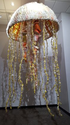 a large jellyfish made out of plastic beads and other items hanging from the ceiling