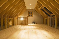 an attic with wooden floors and exposed rafters