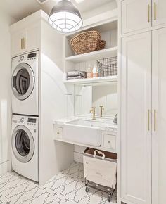 a washer and dryer in a white laundry room with open shelve