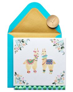 a card with two llamas on it and a gold seal in the middle