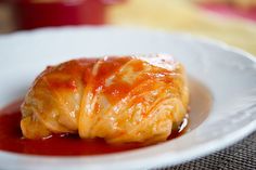 a white plate topped with food covered in sauce