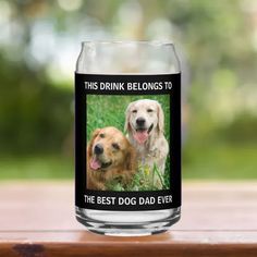 a beer glass with two dogs on it and the caption says, this drink belongs to the best dog dad ever