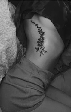 a black and white photo of a woman's stomach with flowers on it