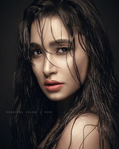 a woman with wet hair posing for the camera