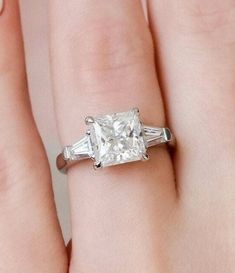 Our gorgeous collection of moissanite engagement rings includes the princess & baguettes 3-stone diamond ring. Our princess-cut diamonds are known for their square shape and are completely symmetrical to maximum brilliance. Accent moissanite features a three-stone style with classic tapered baguettes held in a classic bar setting on either side of the center stone. ✤Material Details✤ ⇒Base Metal: Sterling Silver ⇒Metal Purity: 925 ⇒Stamping: S925 ⇒Plating Option: White Gold, Yellow Gold, Rose Go Wedding Ring Square, White Gold Engagement Rings Princess Cut, Ring Square Diamond, Baguette Side Stones, 3 Stone Diamond Ring, Bar Setting, Baguette Engagement Ring, Princess Cut Moissanite, Ring Square