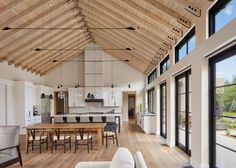 a large open concept living and dining room area with wood flooring, white walls and ceiling