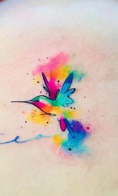 a colorful tattoo on the back of a woman's shoulder