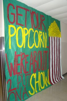 a green sign that says get your popcorn we're about to put on show