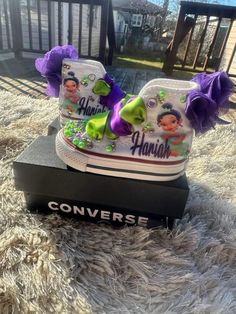 a pair of shoes that have been put on top of a box with purple bows