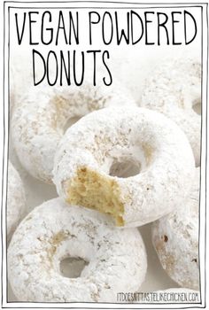 a pile of vegan powdered donuts with a bite taken out of one