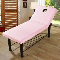 a pink bed sitting on top of a wooden floor