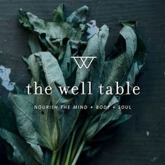 a bunch of green leaves sitting on top of a wooden table with the words, the well table