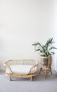 two wicker plant stands next to each other in front of a white painted wall