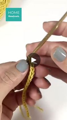 two hands are holding yarn and crochet hooks