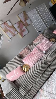 a living room filled with furniture and pink pillows on top of it's covers