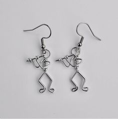 pair of musical notes dangle earrings with dangling hooks in silver tone on white background