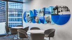 an office with round tables and chairs in front of large windows that have cityscapes on them