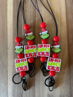 the grin face keychains are decorated with red beads and green letters that say i'm not santa claus