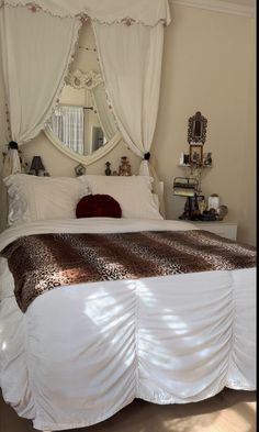 a bed with white sheets and a leopard print comforter on it's headboard