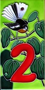 a bird sitting on top of a green plant with the number two painted on it