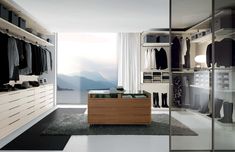 a walk in closet filled with lots of clothes and shoes next to a large window