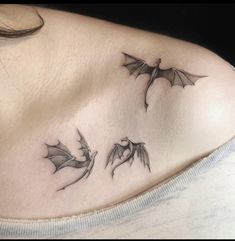 a woman's chest with three small bats on her left shoulder and the other side