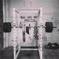 a black and white photo of a squat rack with two barbells on it