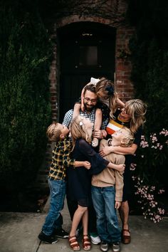 a group of people hugging each other in front of a building