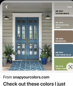 a blue front door with white trim and some green plants on the side walk next to it