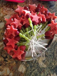 a plate filled with watermelon, grapes and star shaped strawberries on top of a table