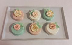 there are six cupcakes with flowers on the top one is pink and green