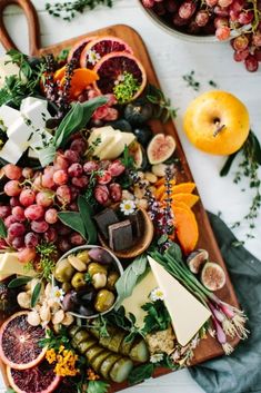 an assortment of fruits and cheeses on a platter