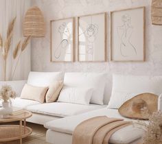 a living room filled with white furniture and paintings hanging on the wall above couches