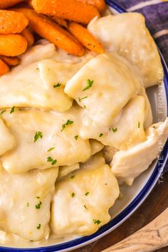 a blue and white plate topped with dumplings and carrots