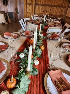 the table is set with candles, plates and place settings for an elegant thanksgiving dinner