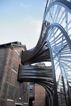 a large metal sculpture in front of a brick building