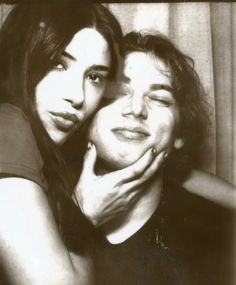 black and white photograph of two people posing for the camera with their hands on each other's face