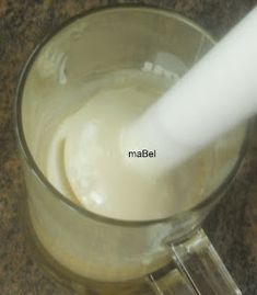 a glass filled with white liquid sitting on top of a counter