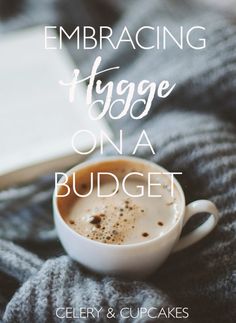 a cup of coffee sitting on top of a blanket with the words embracing hygge on a budget