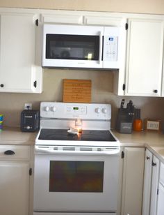 a white stove top oven sitting inside of a kitchen next to microwaves and cabinets