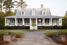 a large white house sitting on top of a lush green field