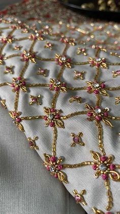 a table cloth with gold and pink beading on it