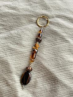 a keychain that has some beads hanging off of it's side on a bed