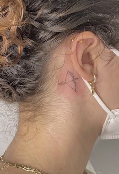 a woman with a small tattoo behind her ear