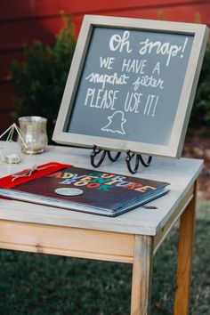 a chalkboard sign sitting on top of a wooden table