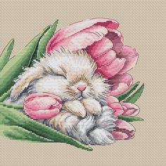 a cross stitch picture of a kitten sleeping on top of a flower