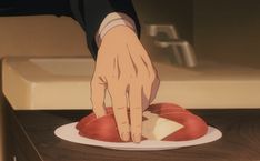 a hand reaching for a piece of food on a plate