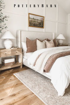 a bedroom with white walls and wood flooring has a large bed in the center